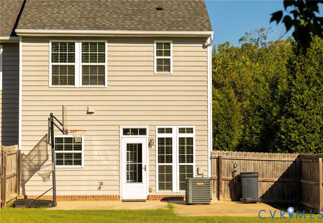 11617 Vicars Ridge Lane, Glen Allen, VA 23059 Rear exterior featuring neutral-toned siding, a shingled roof, multiple windows with grilles, and a privacy fence