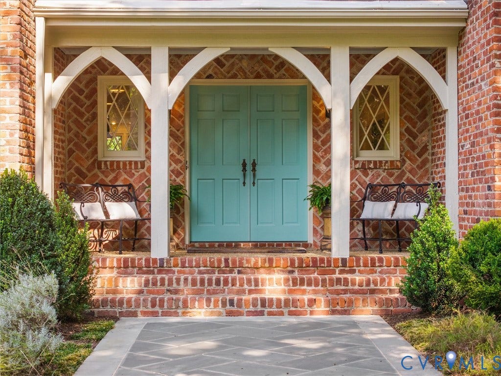 500 Kilmarnock Drive, Collegiate Area, Henrico, VA 23229 Brick exterior featuring a teal double entry door, an arched portico, diamond-pane windows, and a stone-paver walkway
