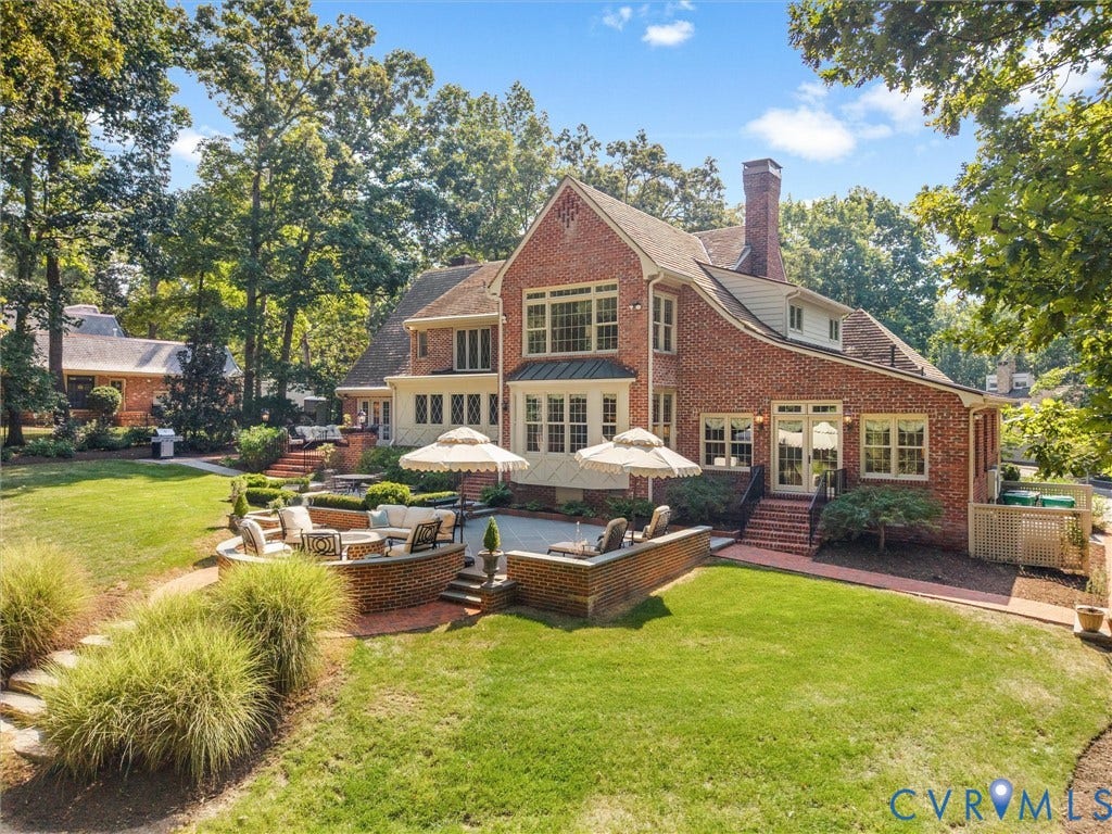 500 Kilmarnock Drive, Collegiate Area, Henrico, VA 23229 Brick exterior with multiple dormer windows, a tiered hardscape patio, an expansive lawn, and mature trees