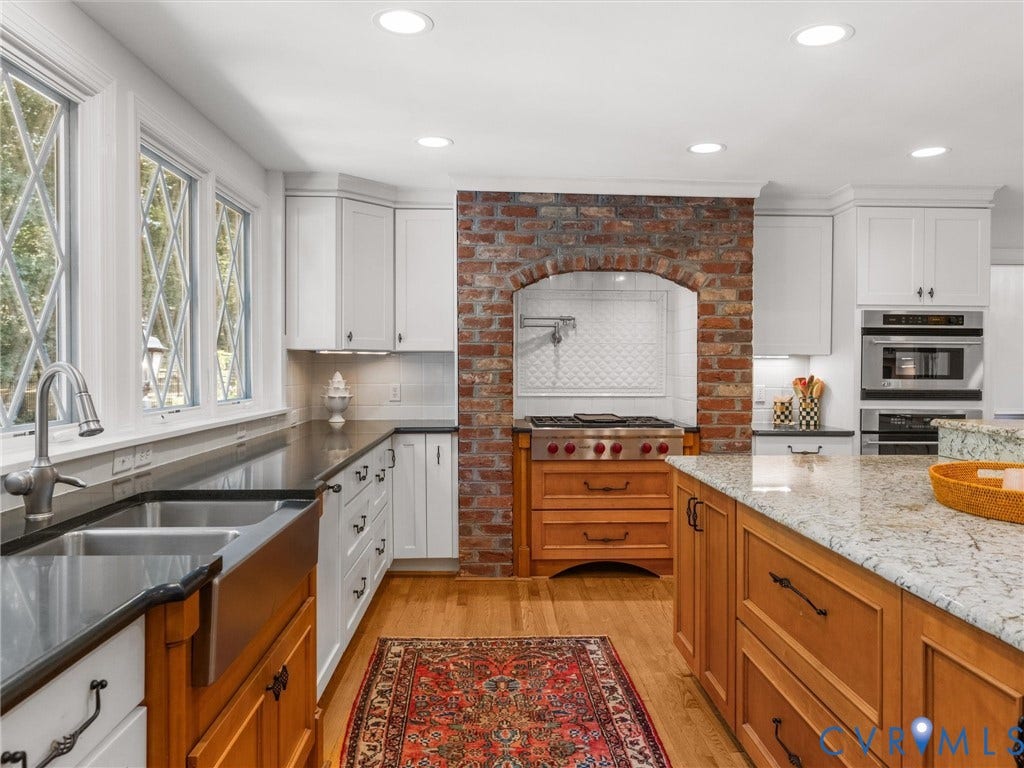 500 Kilmarnock Drive, Collegiate Area, Henrico, VA 23229 Kitchen featuring white cabinetry, brick archway, stainless steel range, wood-finish flooring, and a center island with a light-toned countertop