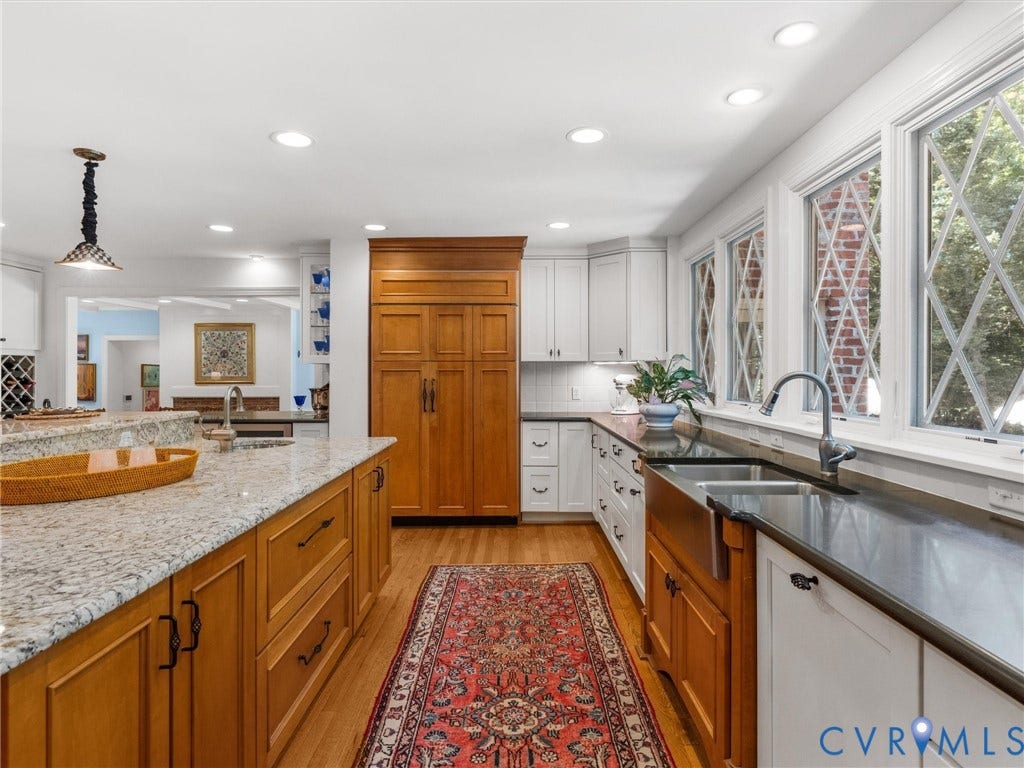 500 Kilmarnock Drive, Collegiate Area, Henrico, VA 23229 Kitchen featuring wood-finish flooring, an expansive island with granite countertops, abundant cabinetry, a built-in refrigerator, and multiple windows