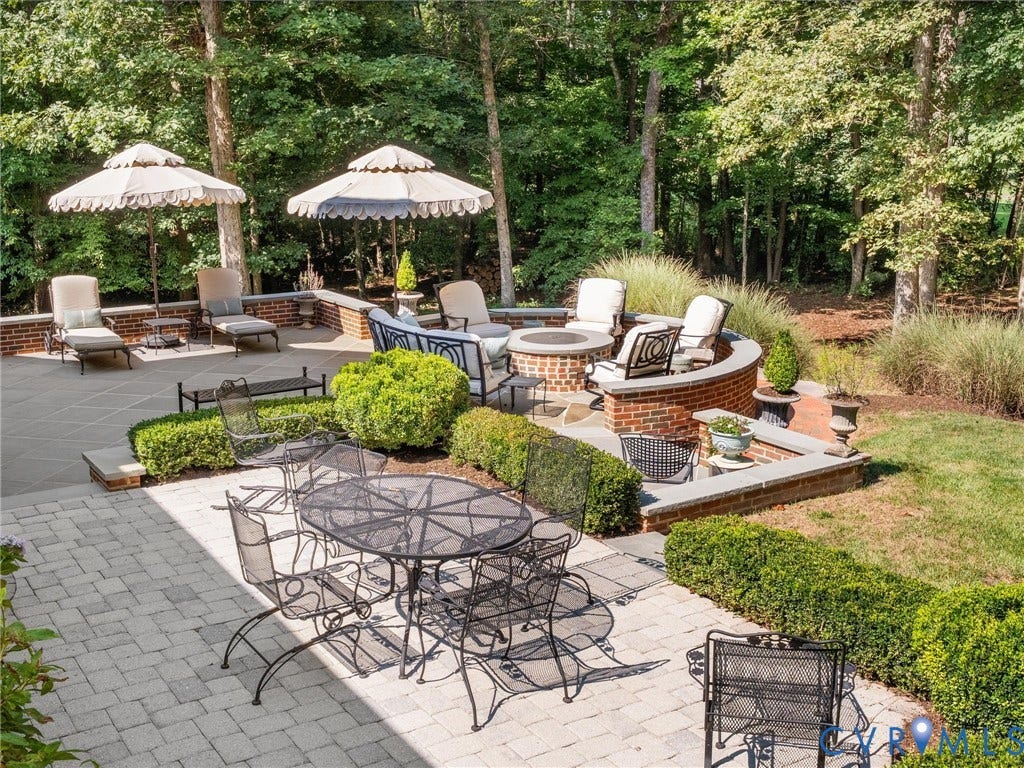 500 Kilmarnock Drive, Collegiate Area, Henrico, VA 23229 Multi-level paver patio featuring a built-in fire pit with brick surround, low brick walls, and integrated landscaping with manicured hedges