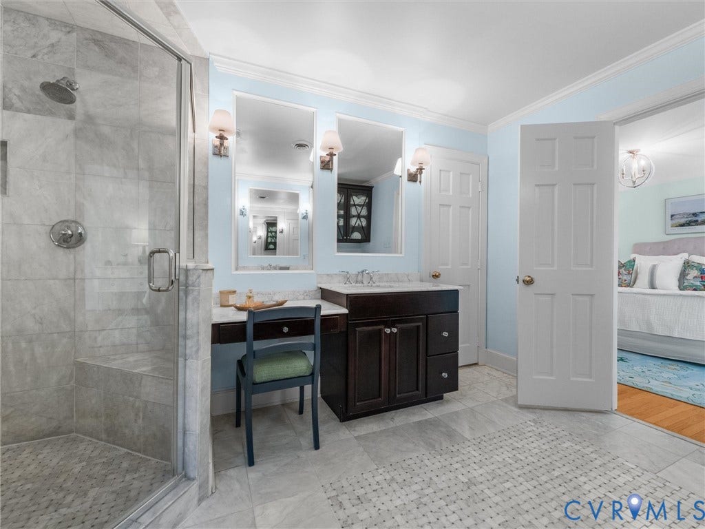 500 Kilmarnock Drive, Collegiate Area, Henrico, VA 23229 Glass-enclosed shower with a built-in bench, dual vanity with undermount sinks, wall-mounted sconces, and light-toned tile flooring