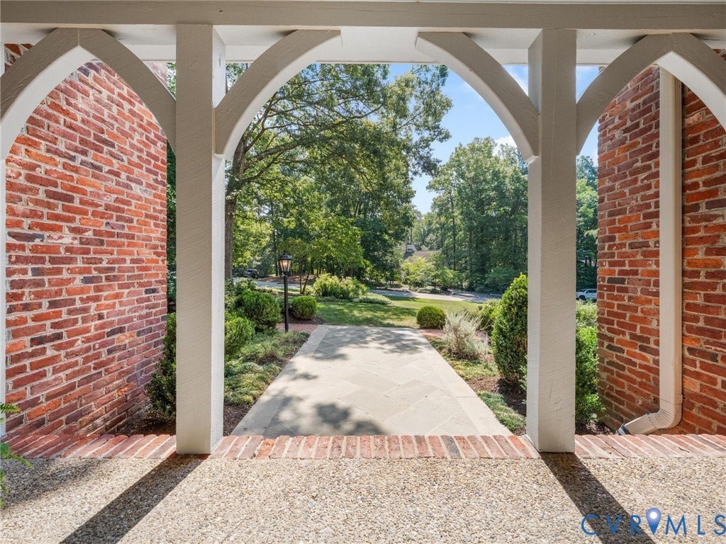 500 Kilmarnock Drive, Collegiate Area, Henrico, VA 23229 Brick exterior with white archway details, a flagstone pathway, and landscaped grounds featuring mature trees and shrubs