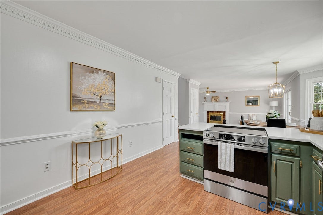 Stainless steel range with a flat cooktop, white countertops, green cabinetry, and wood-finish flooring