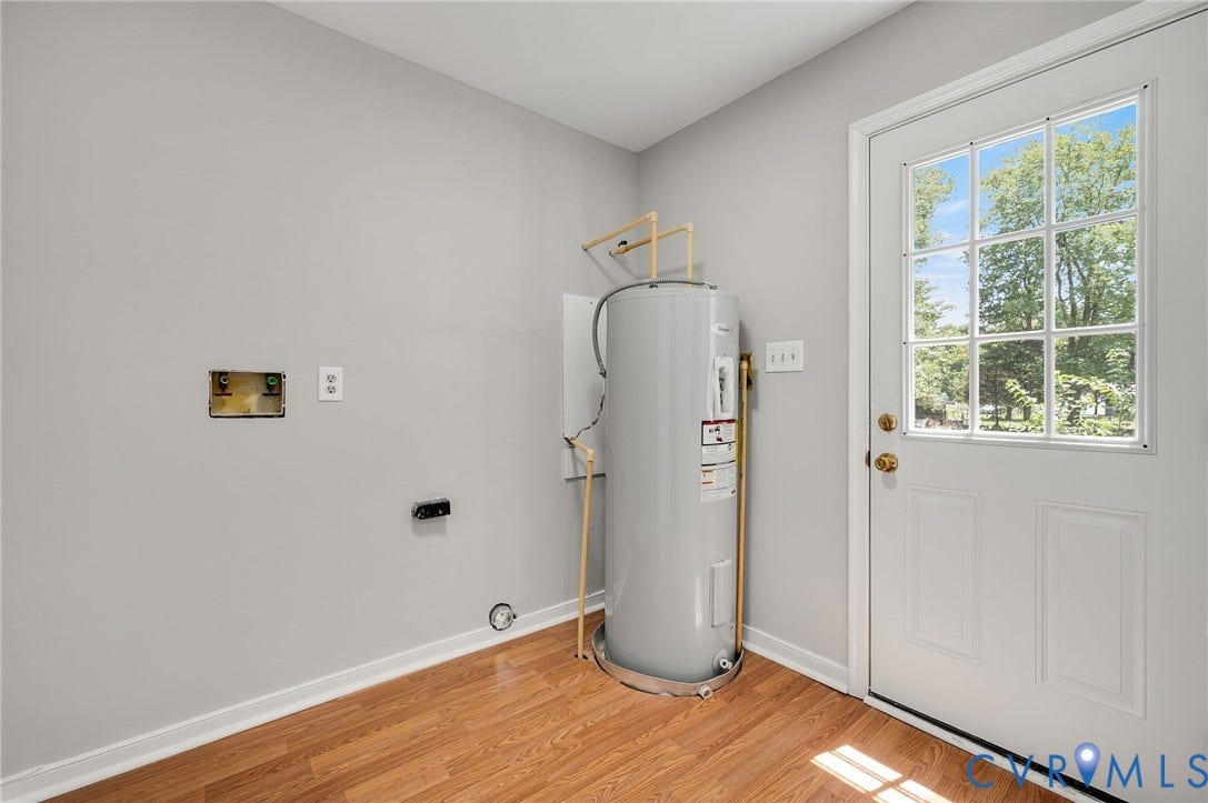 Wood-finish flooring, light gray wall paint, and a glass-paneled door