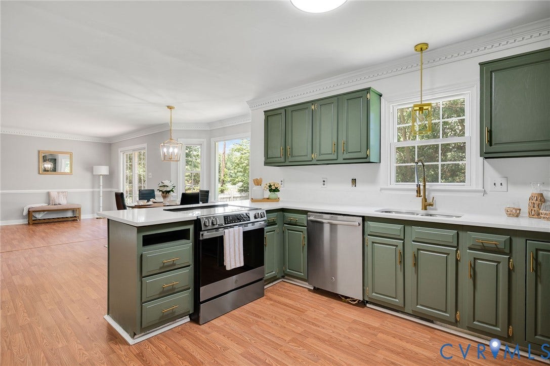 Kitchen featuring green cabinetry, stainless steel appliances, quartz countertops, and wood-finish flooring