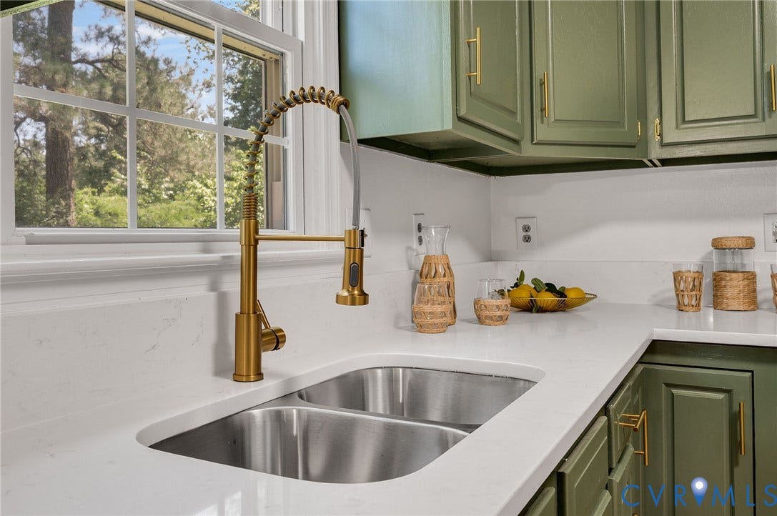 Dual-basin stainless steel sink with a brass-finish pull-down faucet