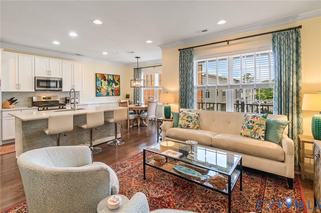 Large formal living space open to kitchen and flooded with natural light