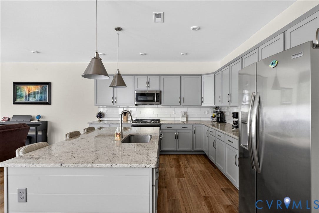 3700 Irby Pond Drive, Midlothian, VA 23112 Kitchen with light gray cabinetry, stainless steel appliances, wood-finish flooring, white subway tile backsplash, and a central island with a sink