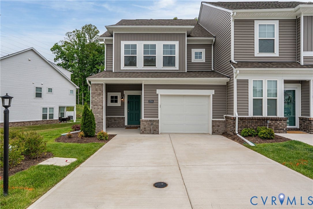 3700 Irby Pond Drive, Midlothian, VA 23112 Two-story property featuring a gray siding facade, white trim windows, brick accents, and a front-facing garage with a concrete driveway