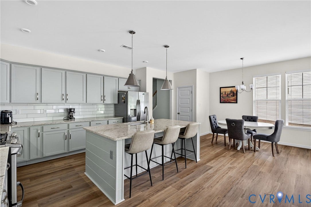 3700 Irby Pond Drive, Midlothian, VA 23112 Kitchen featuring light-toned cabinetry, a granite-finish island with pendant lighting, a subway tile backsplash, and wood-finish flooring
