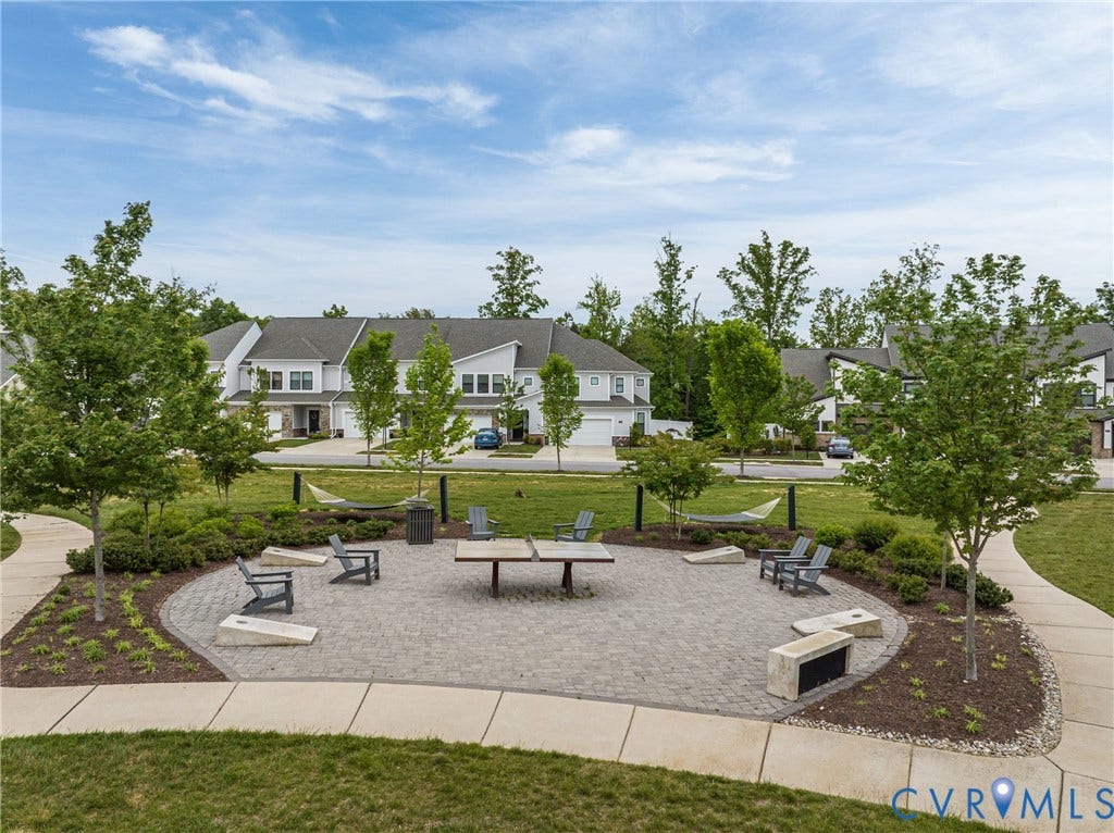 3700 Irby Pond Drive, Midlothian, VA 23112 Paver patio featuring built-in benches and a ping pong table, surrounded by mature trees and landscaped shrubbery