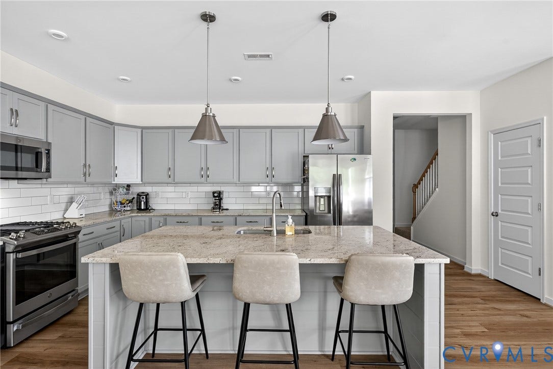 3700 Irby Pond Drive, Midlothian, VA 23112 Kitchen featuring a large island with seating, pendant lighting, stainless steel appliances, and wood-finish flooring