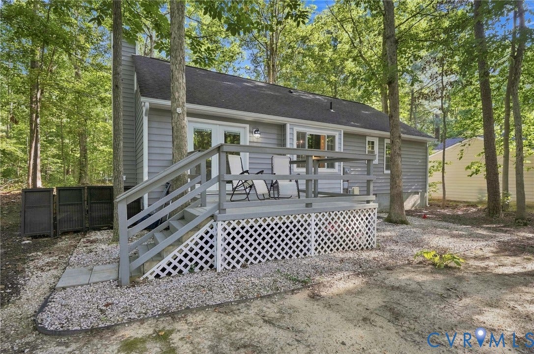 13700 Carriage Creek Place, Chesterfield, VA 23112 Rear exterior with gray siding, a gray wood deck with white lattice skirting, and a dark shingle roof
