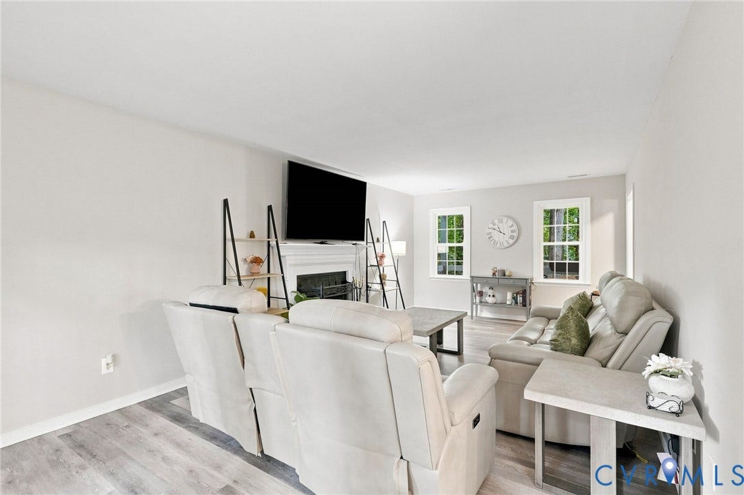 13700 Carriage Creek Place, Chesterfield, VA 23112 Living area featuring light-toned walls, wood-finish flooring, white window trim, and a built-in fireplace with a white mantel