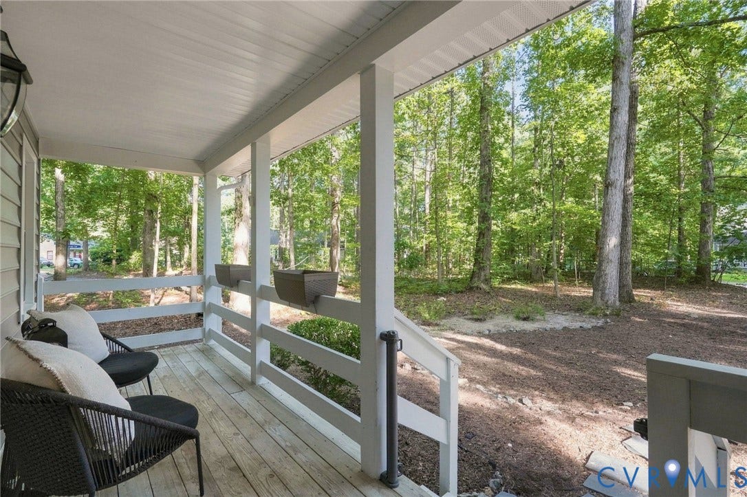 13700 Carriage Creek Place, Chesterfield, VA 23112 Covered porch with wood-finish flooring and slatted railing, surrounded by mature trees