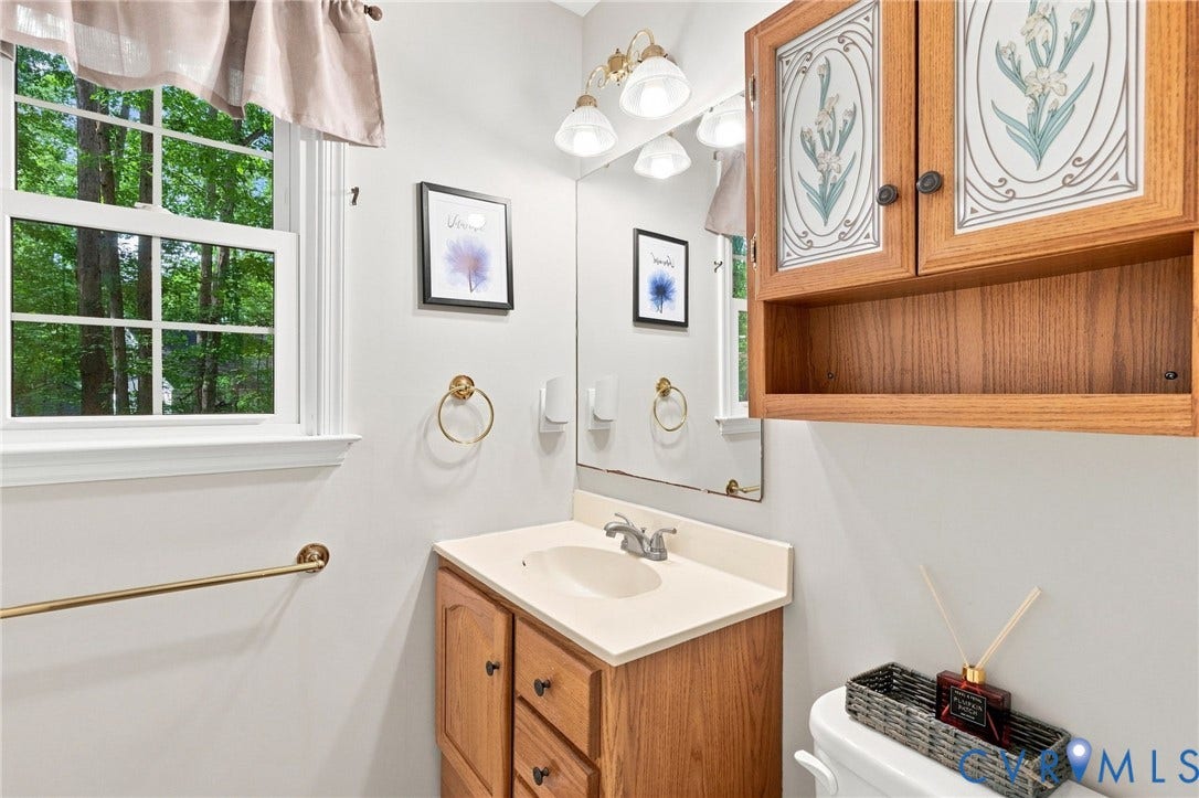13700 Carriage Creek Place, Chesterfield, VA 23112 Wood-finish vanity with an integrated sink and light-toned countertop