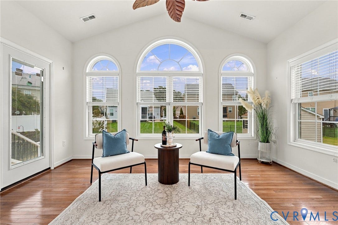 9619 Redwick Drive, Matoaca, Chesterfield, VA 23112 Vaulted ceiling with a ceiling fan, arched windows, rectangular windows with blinds, wood-finish flooring, and a glass-paneled door