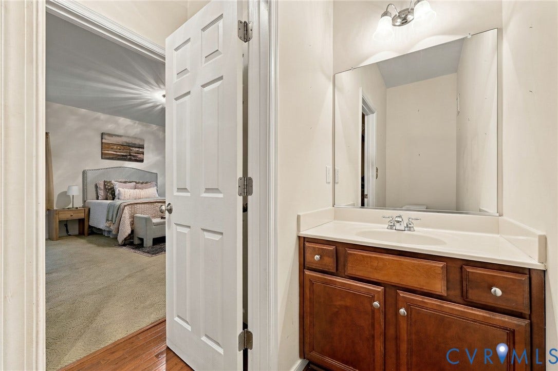 9619 Redwick Drive, Matoaca, Chesterfield, VA 23112 Wood-finish flooring leading into a carpeted room with a built-in vanity, integrated sink, and an overhead light fixture