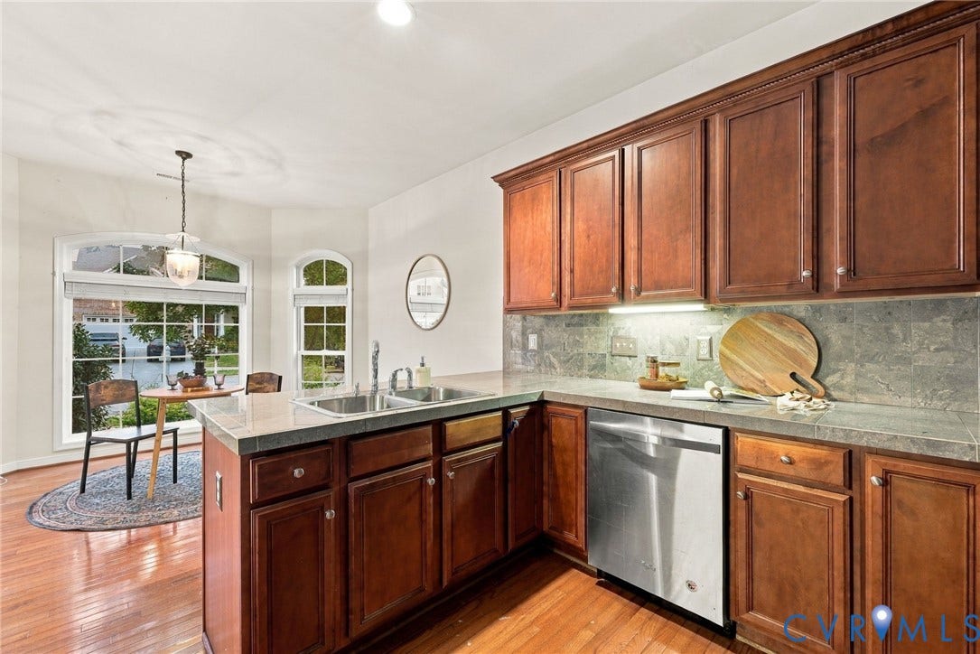 9619 Redwick Drive, Matoaca, Chesterfield, VA 23112 Kitchen featuring wood-finish cabinetry, stainless steel dishwasher, tile backsplash, and light-toned countertops