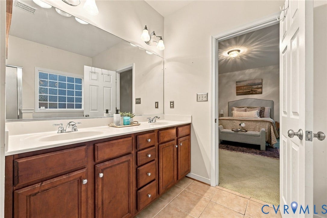9619 Redwick Drive, Matoaca, Chesterfield, VA 23112 Double vanity with wood cabinetry and undermount sinks, large wall-mounted mirror, and tile flooring