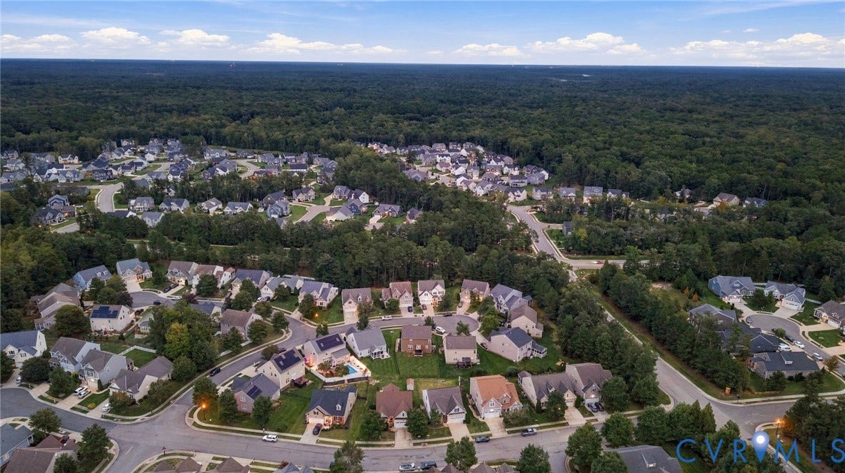 9619 Redwick Drive, Matoaca, Chesterfield, VA 23112 Aerial perspective showcasing a residential community bordered by extensive wooded areas, featuring numerous detached properties and established street infrastructure