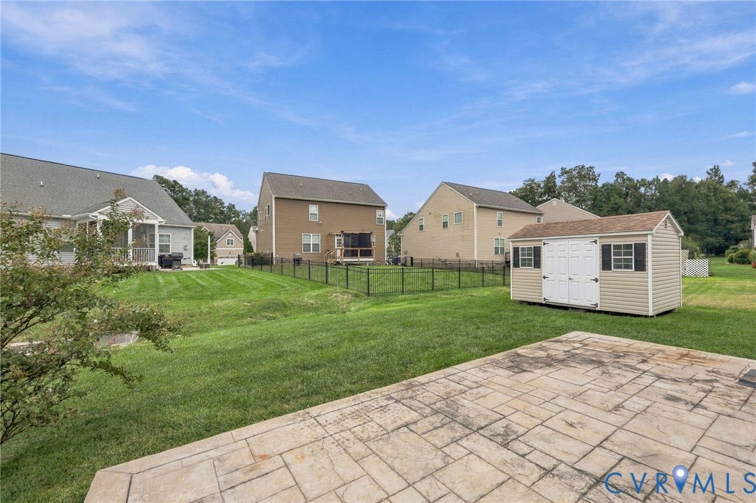 9619 Redwick Drive, Matoaca, Chesterfield, VA 23112 Spacious backyard featuring a stamped concrete patio, expansive lawn, and a detached storage shed