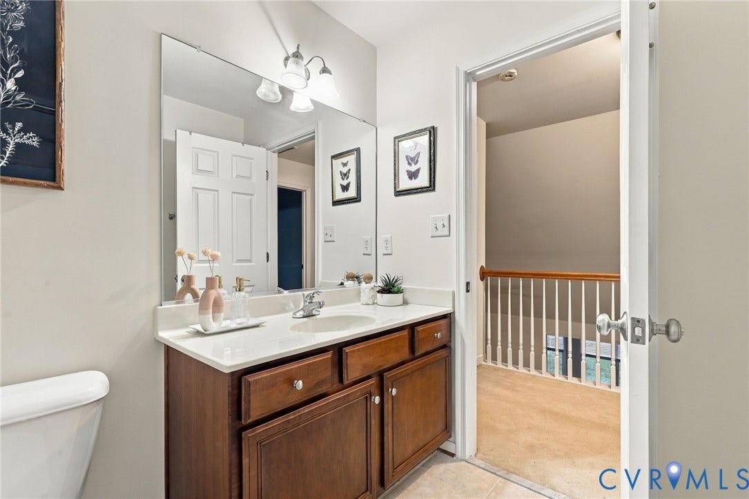 9619 Redwick Drive, Matoaca, Chesterfield, VA 23112 Spa-inspired primary bathroom featuring a wood-finish vanity with dual drawers and cabinet storage, white quartz countertop, and chrome fixtures