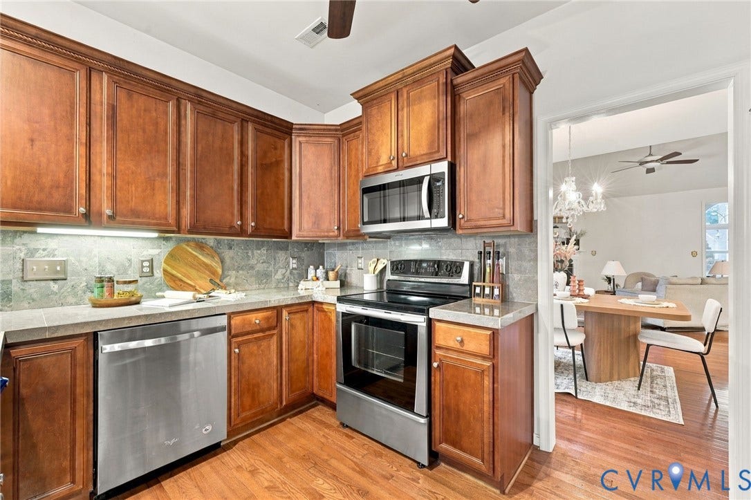 9619 Redwick Drive, Matoaca, Chesterfield, VA 23112 Wood-finish cabinetry with crown molding, stainless steel appliances, natural stone backsplash, and light-toned countertops