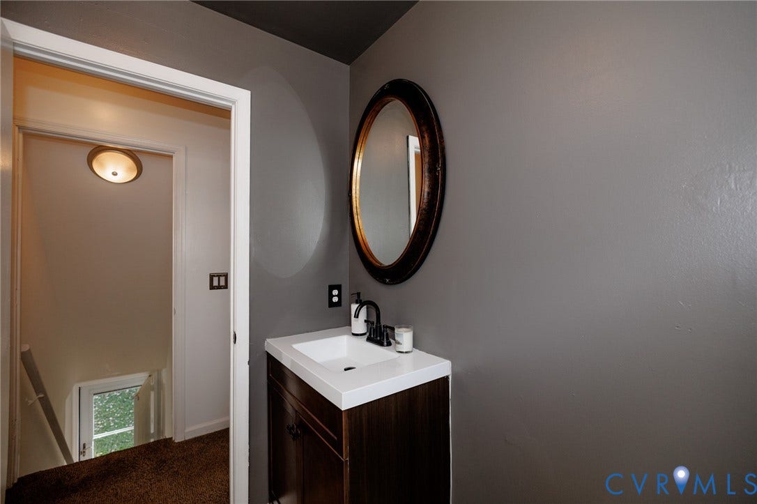 20520 Cox Road, Sutherland, VA 23885 Modern vanity with an integrated white sink, dark wood-finish cabinetry, and a black faucet