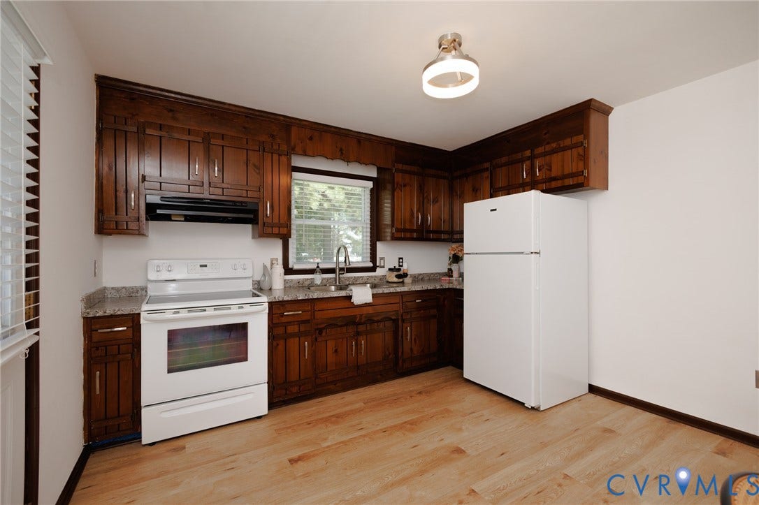 20520 Cox Road, Sutherland, VA 23885 Kitchen featuring abundant wood cabinetry, light-toned wood-finish flooring, and white appliances