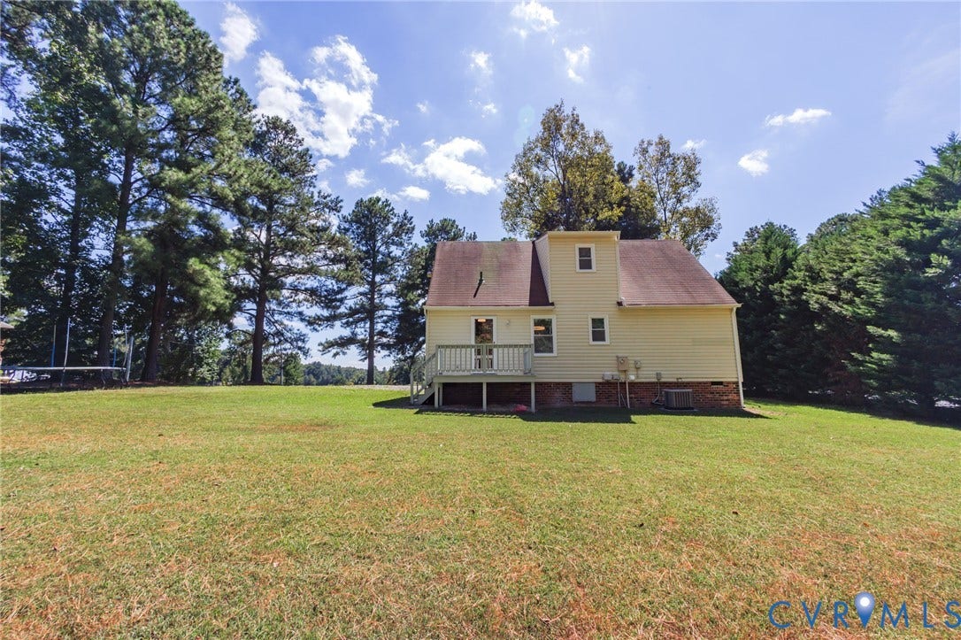 20520 Cox Road, Sutherland, VA 23885 Expansive grassy yard with a deck, surrounded by mature trees, and featuring a siding exterior