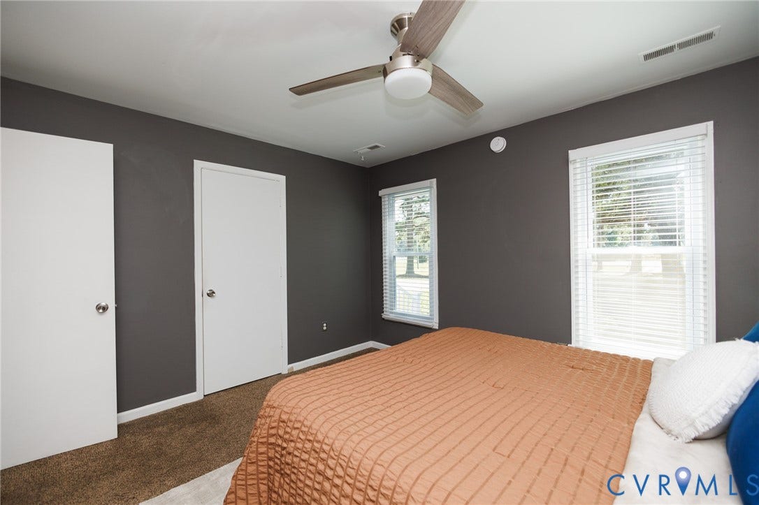 20520 Cox Road, Sutherland, VA 23885 Warm-toned walls accentuating two white doors, two windows, and a ceiling fan with light fixture