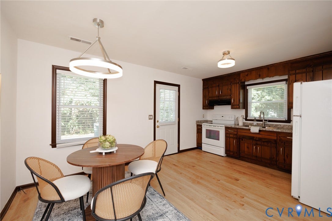 20520 Cox Road, Sutherland, VA 23885 Wood-finish flooring, dark wood cabinetry, light-toned countertops, and a white appliance suite