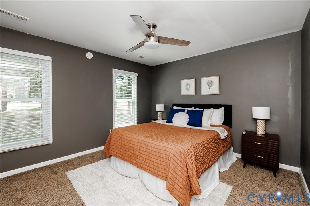 20520 Cox Road, Sutherland, VA 23885 Carpeted flooring, two windows with white blinds, a ceiling fan, and painted walls