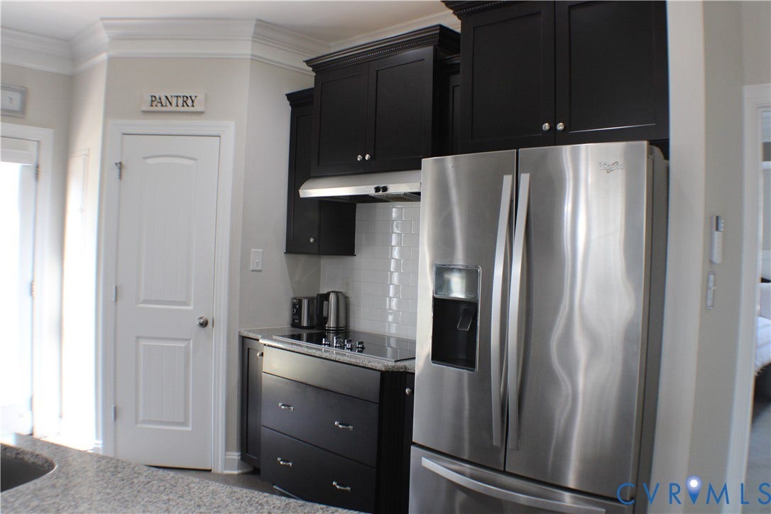 7016 Hawser Lane, Watermark, North Chesterfield, VA 23234 Elegant chef's kitchen w/ stainless steel appliances, wall oven, cooktop, granite counters, tons of beautiful cabinets w/ crown molding, separate crown in kitchen & walk in pantry for great storage!