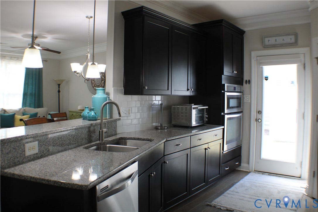 7016 Hawser Lane, Watermark, North Chesterfield, VA 23234 Elegant chef's kitchen w/ stainless steel appliances, wall oven, cooktop, granite counters, tons of beautiful cabinets w/ crown molding, separate crown in kitchen & walk in pantry for great storage!