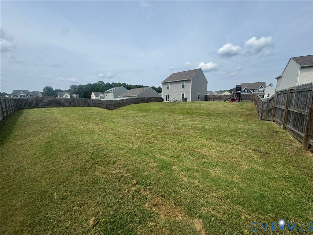 Expansive lawn with wood privacy fencing