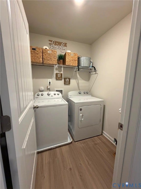 Dedicated laundry area featuring vynil shelving, wood-finish flooring, and a white paneled door