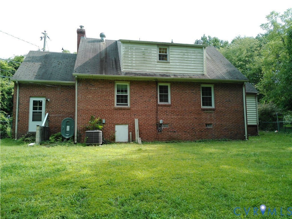 6902 Old Jahnke Road, Richmond, VA 23225 Brick exterior with dormer window, two ground-level access doors, and a sloped roof