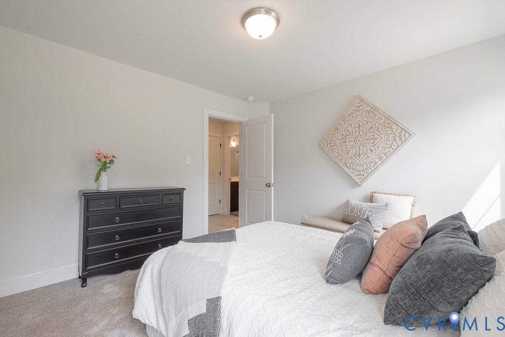 Neutral wall color, wall-to-wall carpeting, overhead flush-mount lighting, and a white interior door