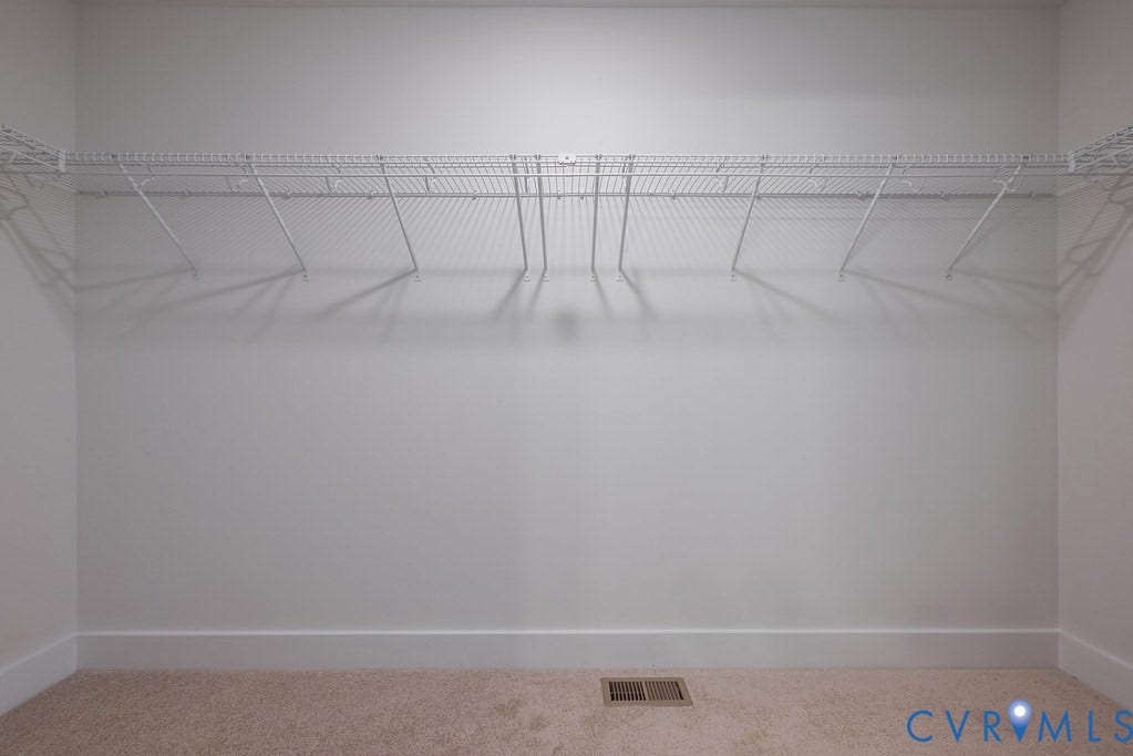 Built-in wire shelving system, light-toned walls, and carpet flooring