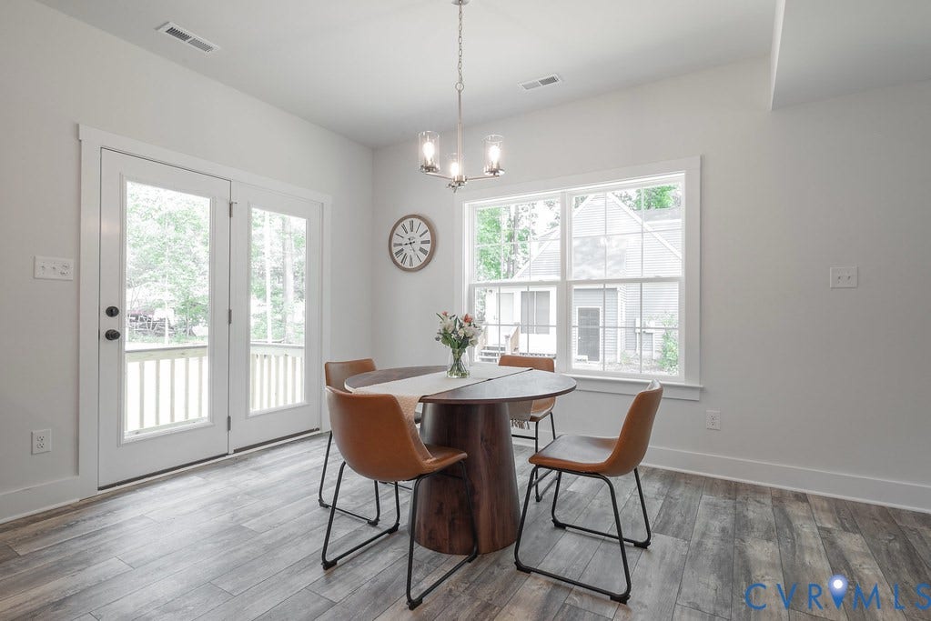 White walls, wood-finish flooring, and a multi-pane window