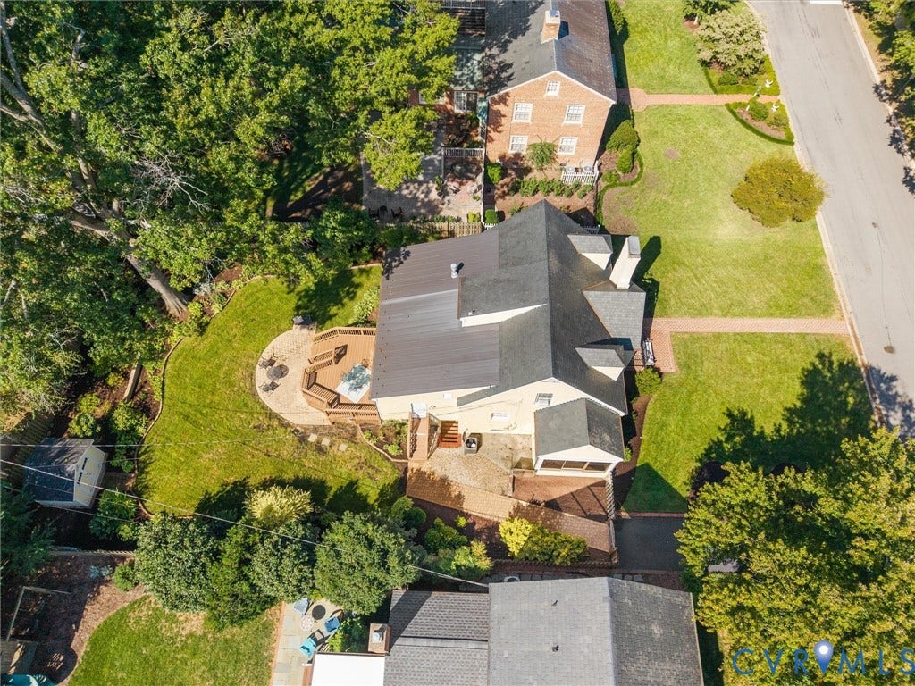 Expansive backyard featuring a multi-level wood deck, integrated hot tub, and a circular paver patio