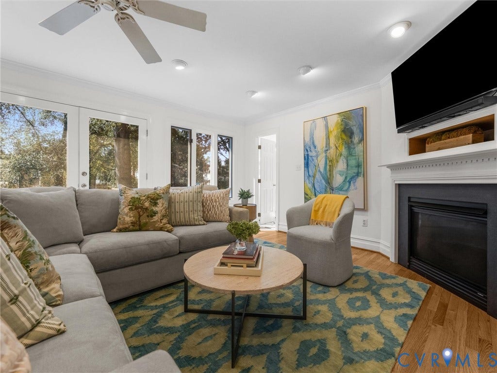 Living area featuring a fireplace with classic white mantel, wood-finish flooring, recessed lighting, and a ceiling fan