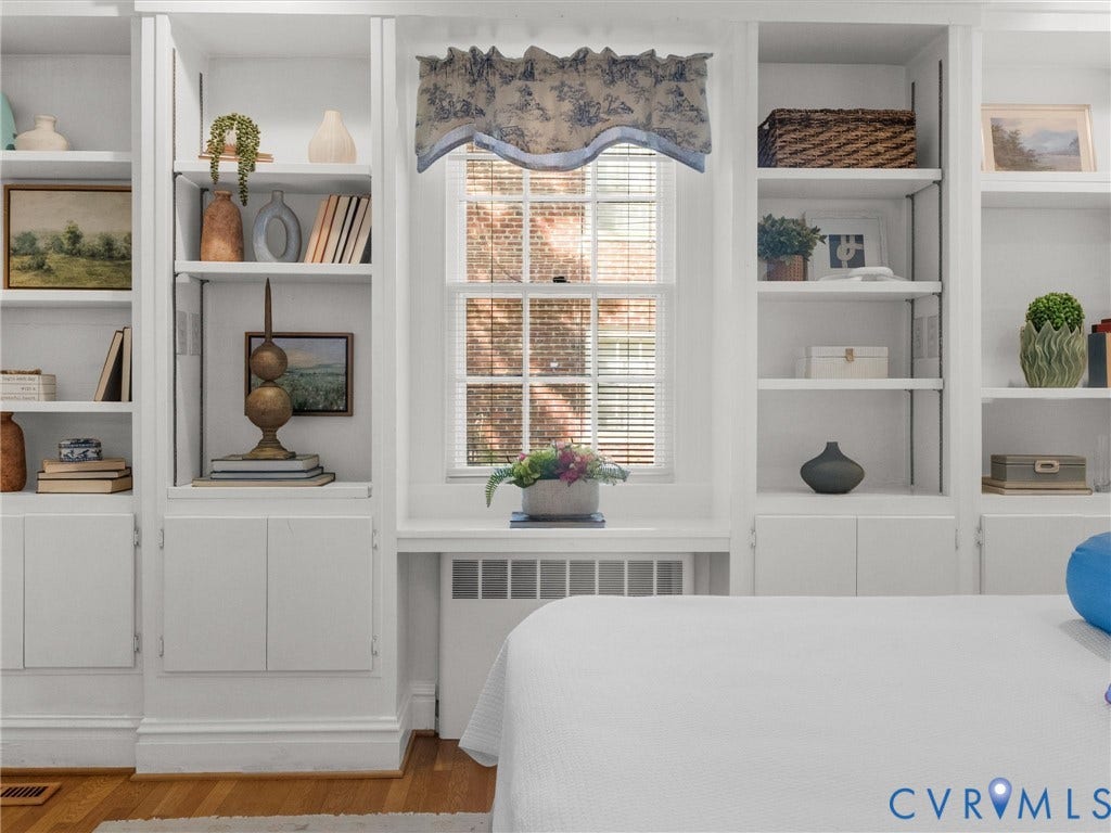 Built-in shelving with adjustable shelves, integrated cabinetry, and a double-hung window