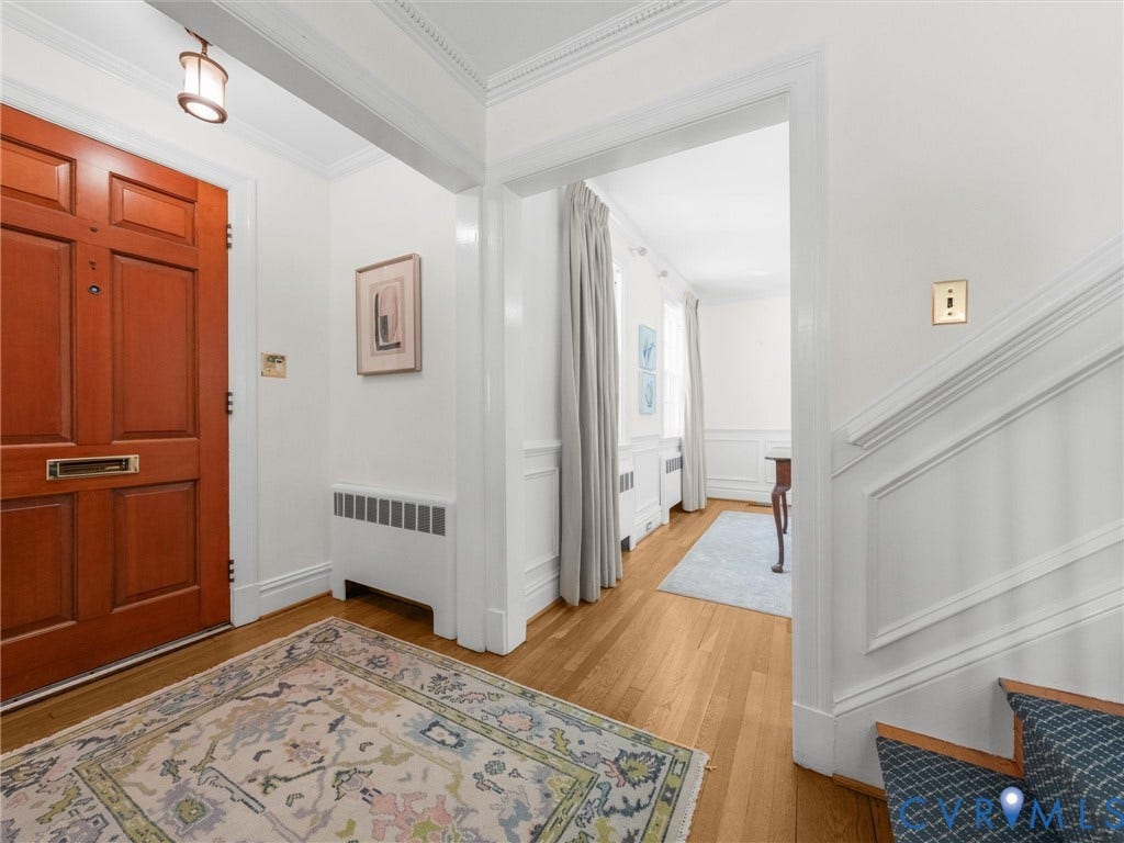 Hardwood flooring and detailed crown molding enhance this entryway