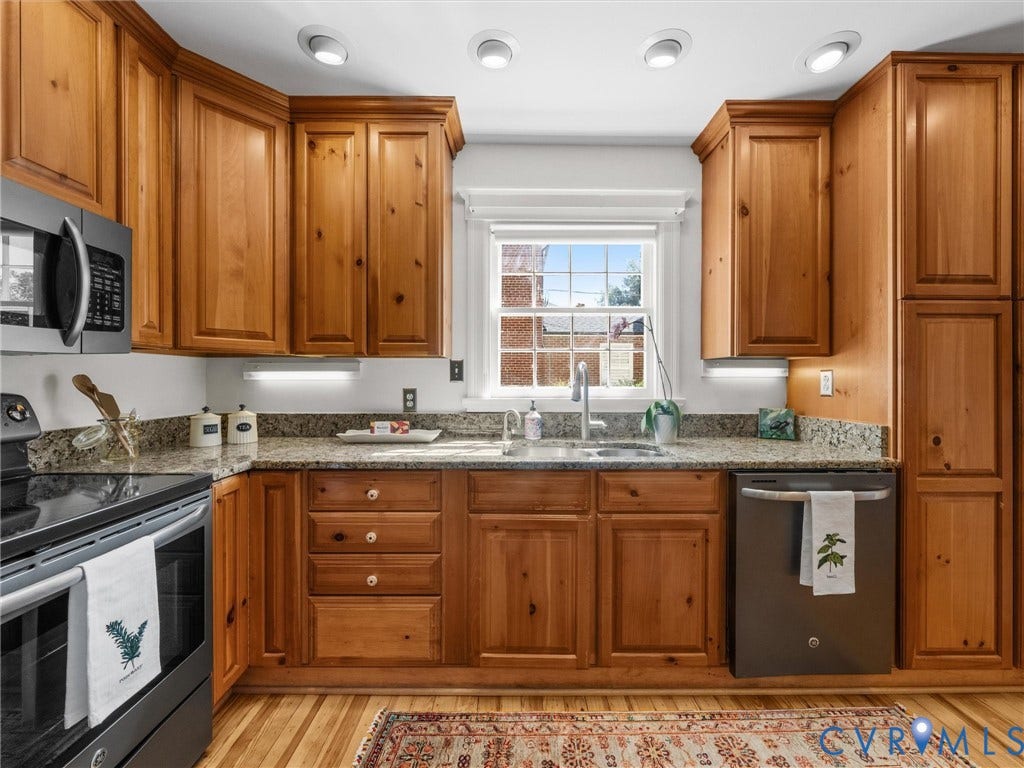 Kitchen with wood-finish cabinetry, stainless steel appliances, granite countertops, and recessed lighting