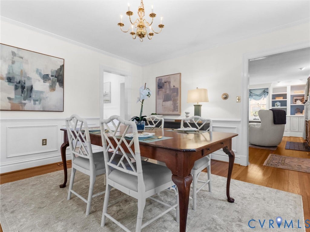 Hardwood flooring, crown molding, chair rail molding, and a chandelier